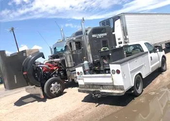 a truck with a tractor trailer parked on the side of the road