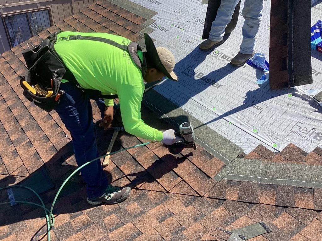 A Tucson roofing contractor inspects a residential roof for damage, missing shingles, and signs of water infiltration.