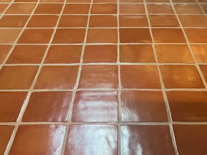 Close-up of clean, glossy Saltillo tile with evenly spaced grout lines, highlighting the tile's natural terracotta color and texture.