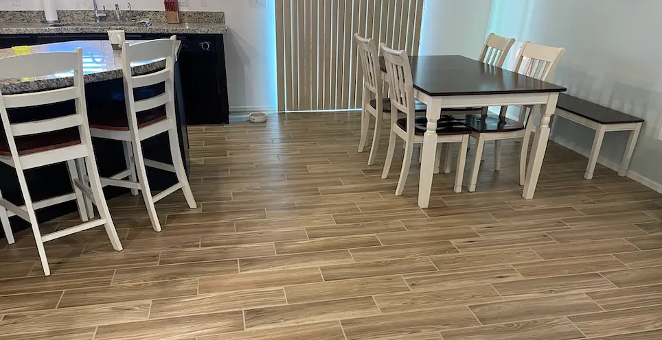 A tile expert from Tucson Tile and Grout cleaning tile and restoring grout in living room