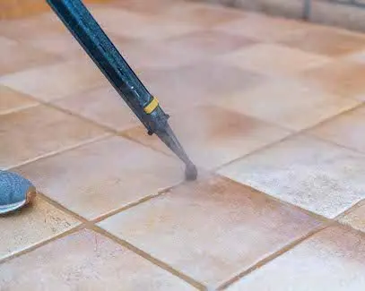 Steam grout cleaning tool treating tile floor grout in Tucson home
