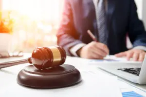 Attorney Working in Courtroom with Wooden Gavel on Table