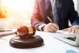 Attorney Working in Courtroom with Wooden Gavel on Table