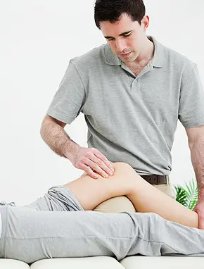Physical therapist performing manual therapy on patient's knee during personalized physical therapy session at Multi-Specialty Pain Management