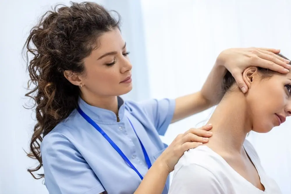 Female physical therapist performing gentle neck examination and manual therapy on a patient with neck pain, checking range of motion and alignment at Multi-Specialty Pain Management in Bronx, NY