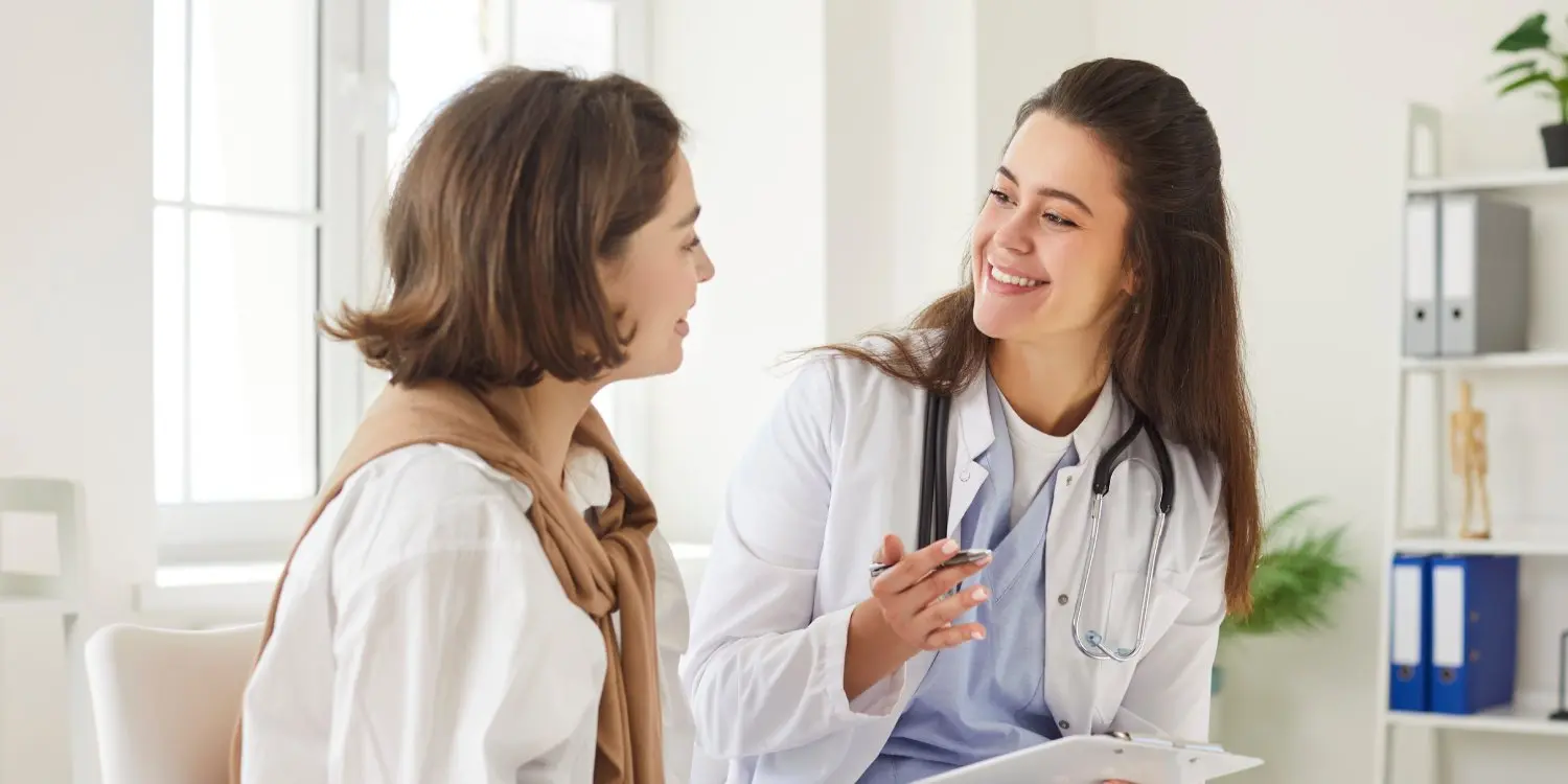 Un médico especialista en lesiones hablando con un paciente durante una consulta médica en Select Injury Doctors, en Nueva York