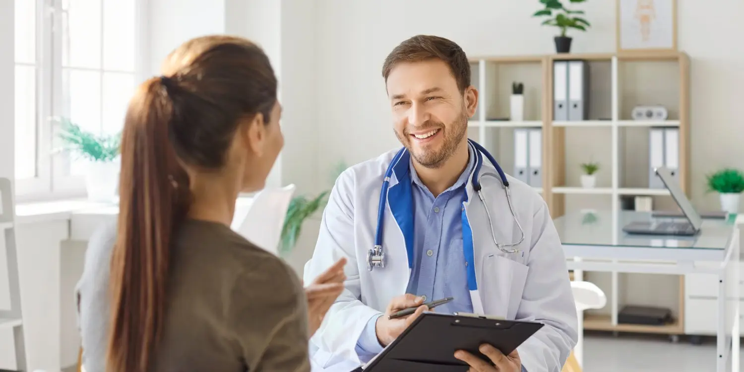 Un médico que consulta con un paciente sobre el cuidado de una lesión y las opciones de tratamiento en una consulta médica