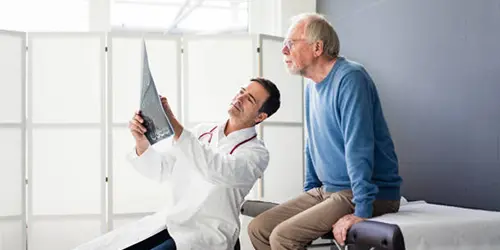 Injury doctor examining a patient’s leg in a clinic – Florida auto accident and trauma doctor near me