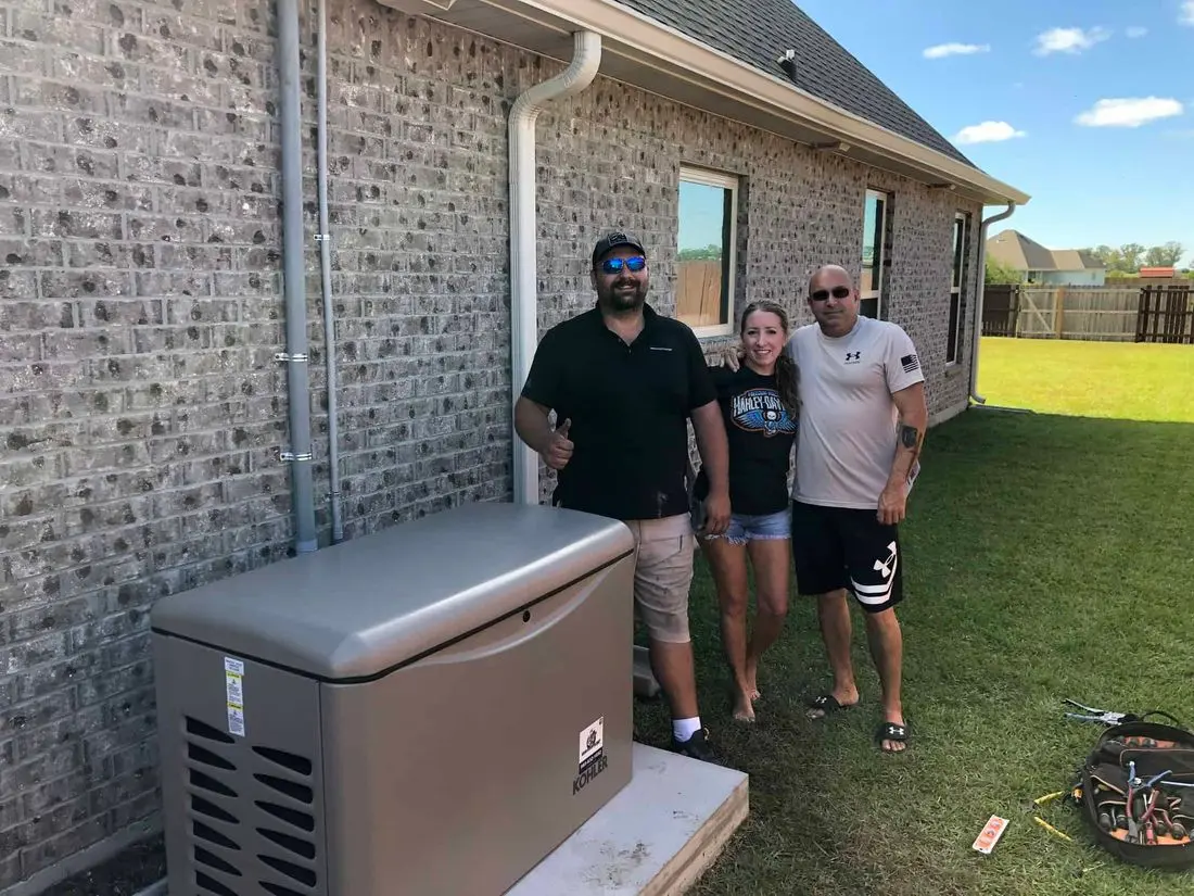 Gengatorz customer Happy couple standing next to backup generator installed next to brick house