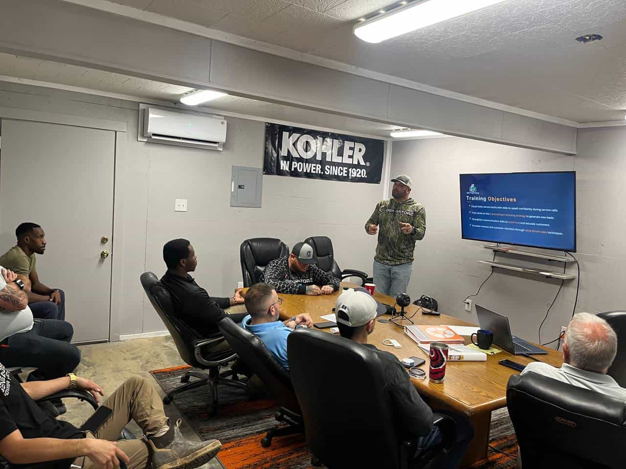Employees in a training room looking at a speaker