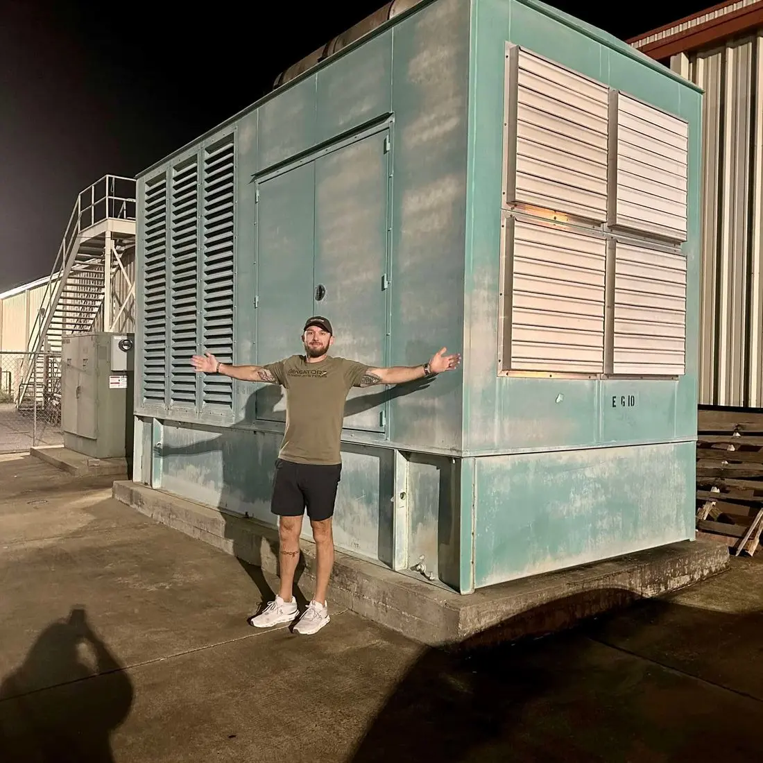 Travis the owner of Gengatorz standing next to a very large commercial generator