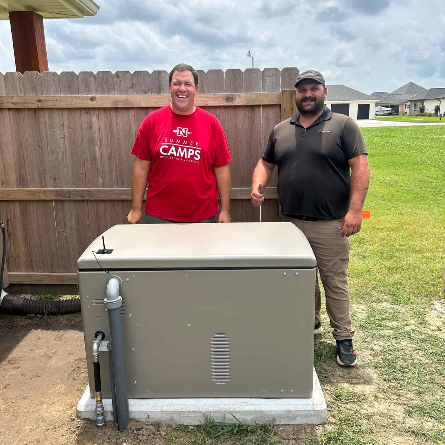 Tech and homeowner standing next to installed generator