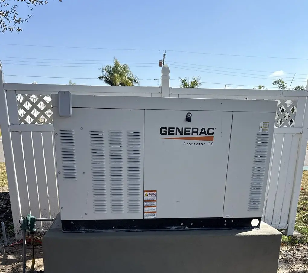 Generac commercial standby generator installed behind a white privacy fence