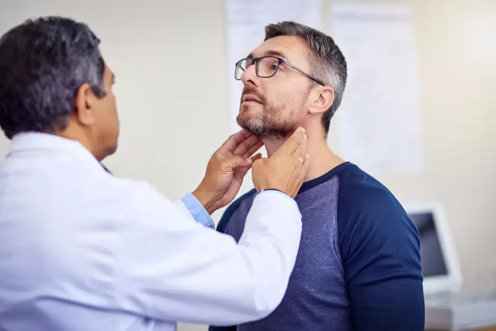 Doctor examining man's throat