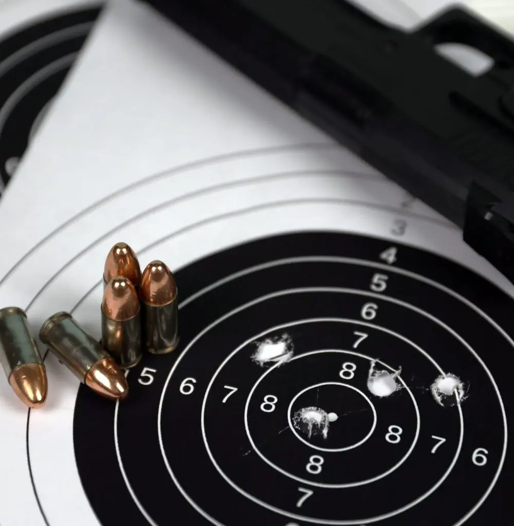 gun-and-many-bullets-shooting-targets-on-white-table-in-shooting-range-polygon-training-for-aiming.jpg Pistol Training