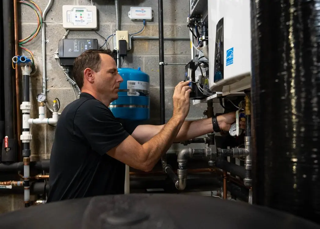 plumber maintaining tankless water heater