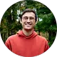Man in orange hoodie smiling outdoors Takeoff-Moving Toronto