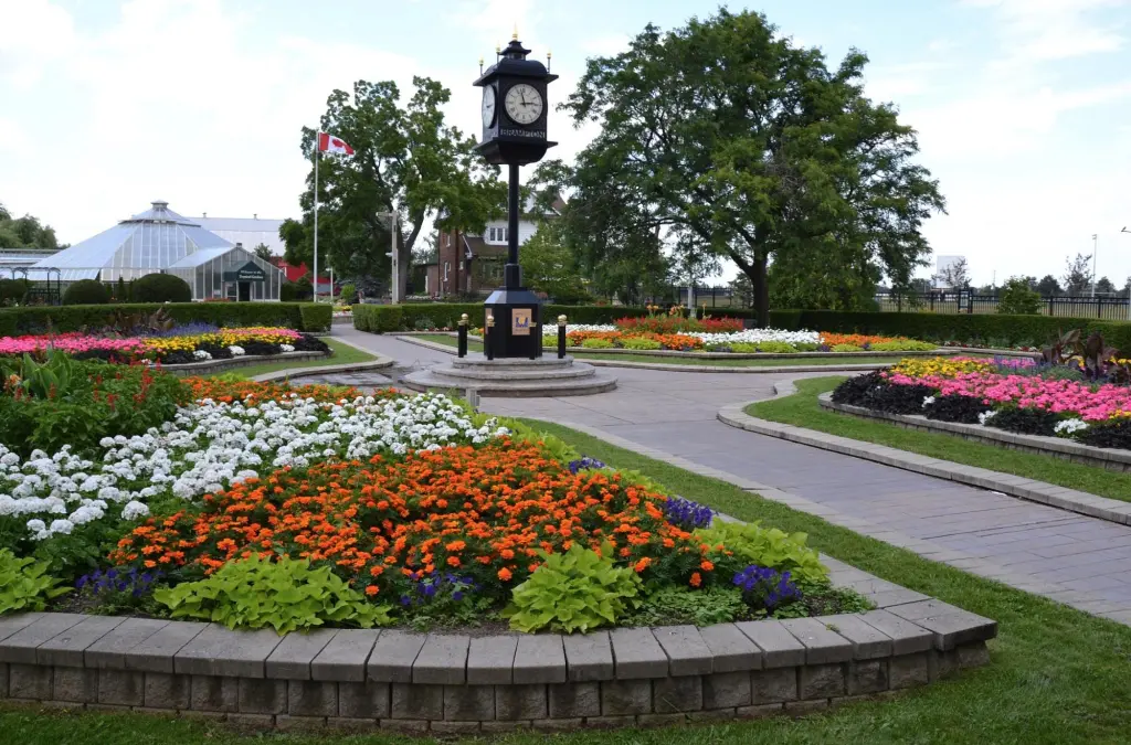 Formal garden with colorful flower beds, a clock tower, and a greenhouse. Takeoff-Moving Toronto