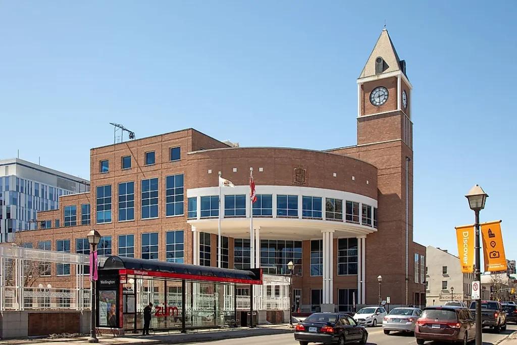 Guelph City Hall with clock tower and bus shelter on a sunny day. Takeoff-Moving Toronto