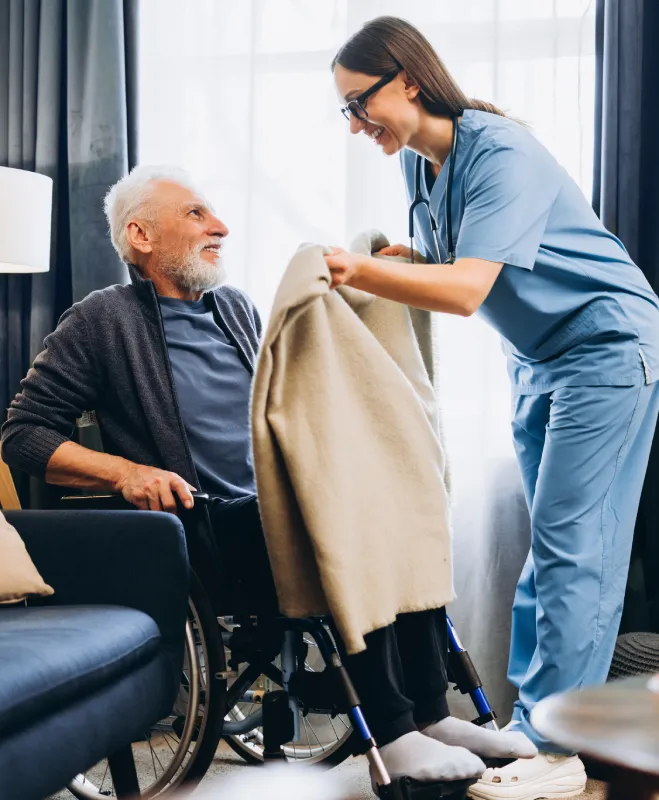 Caregiver helping resident stay warm in assisted living Caregiver helping resident stay warm in assisted living