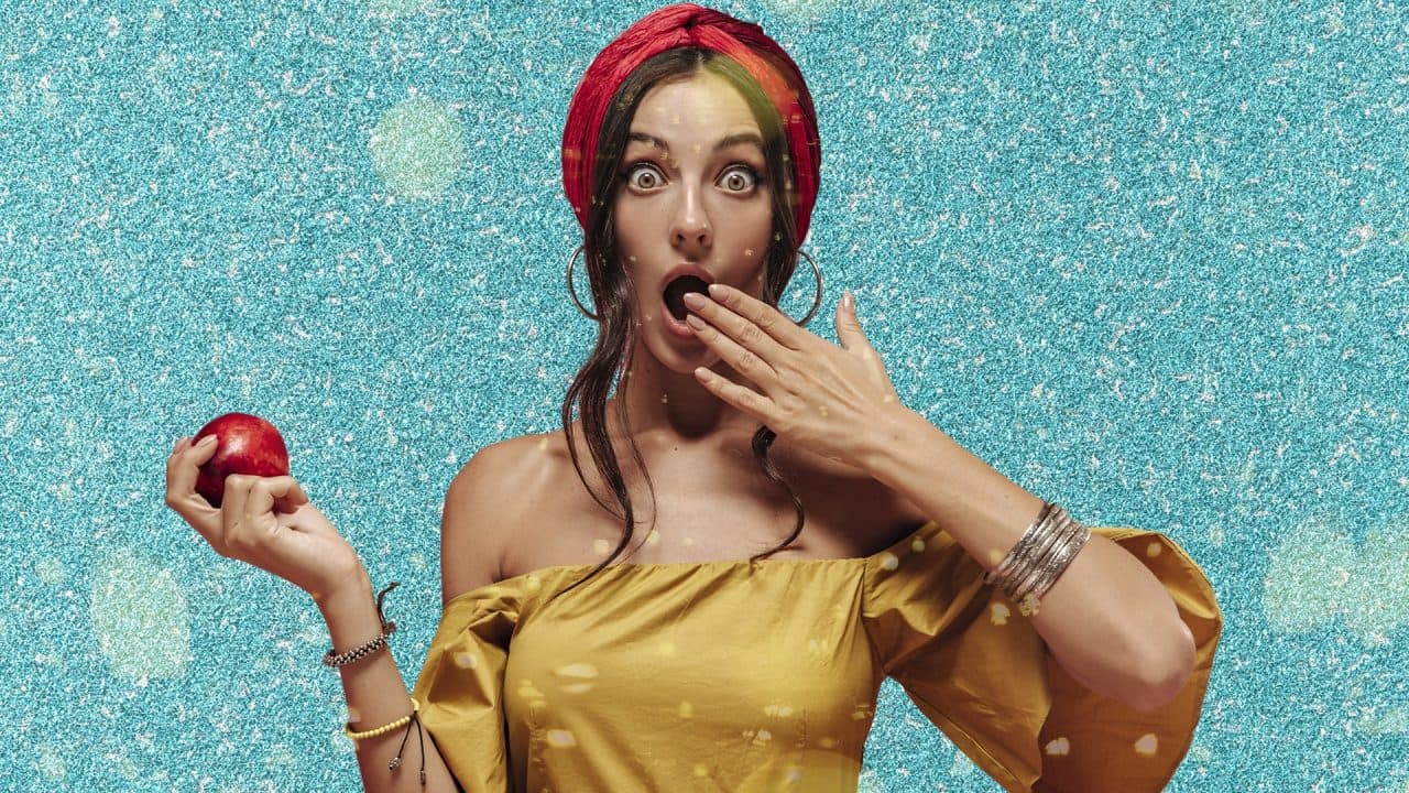 a woman who is surprised holding an apple