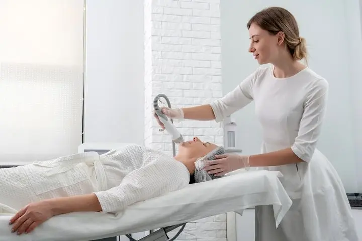 Mature woman receiving ultherapy treatment in modern cosmetology clinic