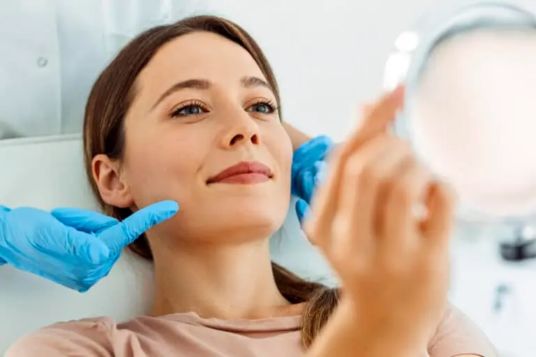 woman looks into mirror at medical Spa