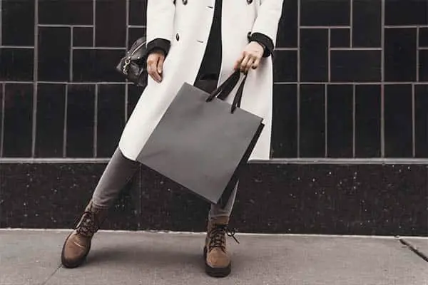 a woman standing holding a bag