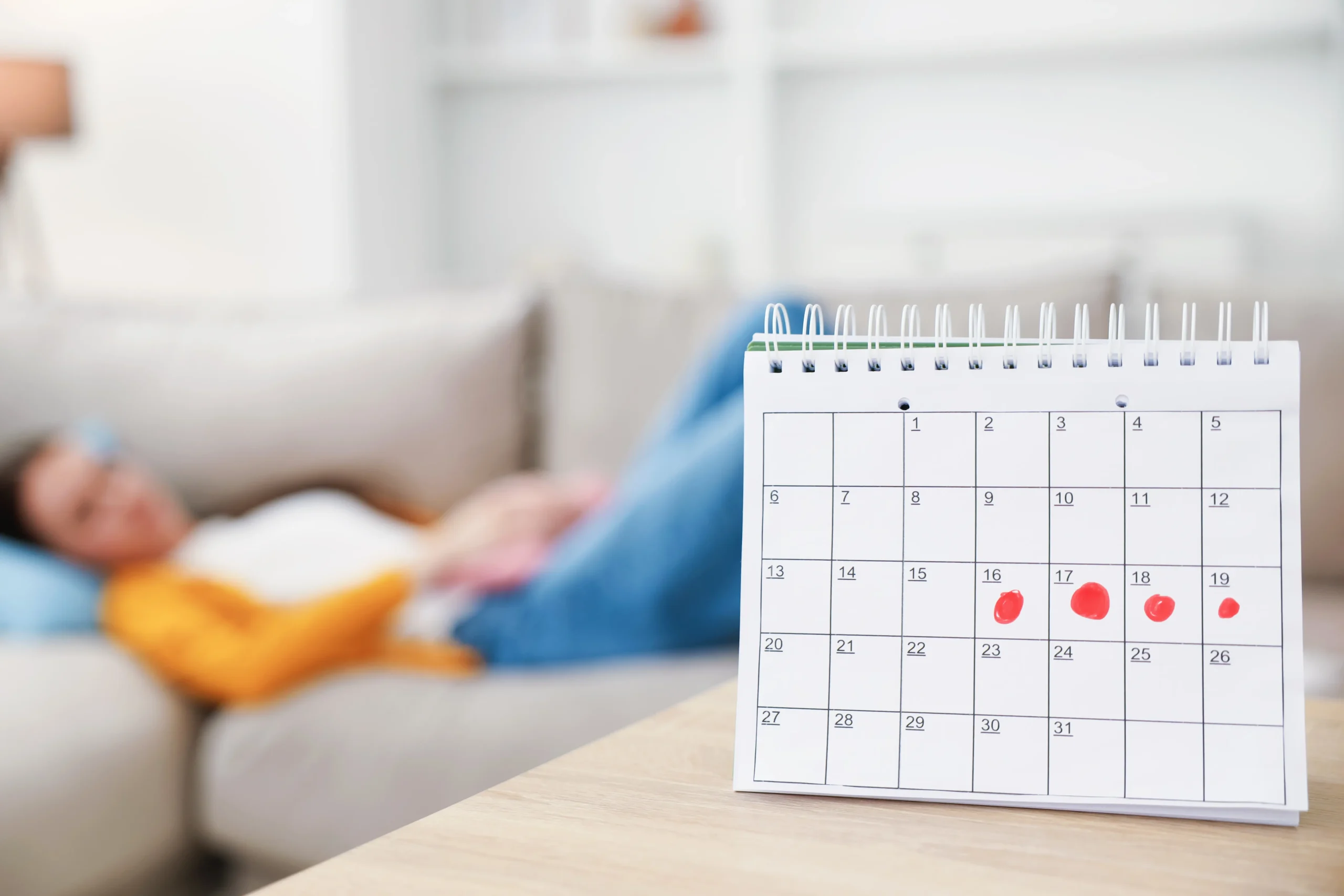 woman resting on couch near calendar with red mens 2026 09 25 03 59 33 utc scaled