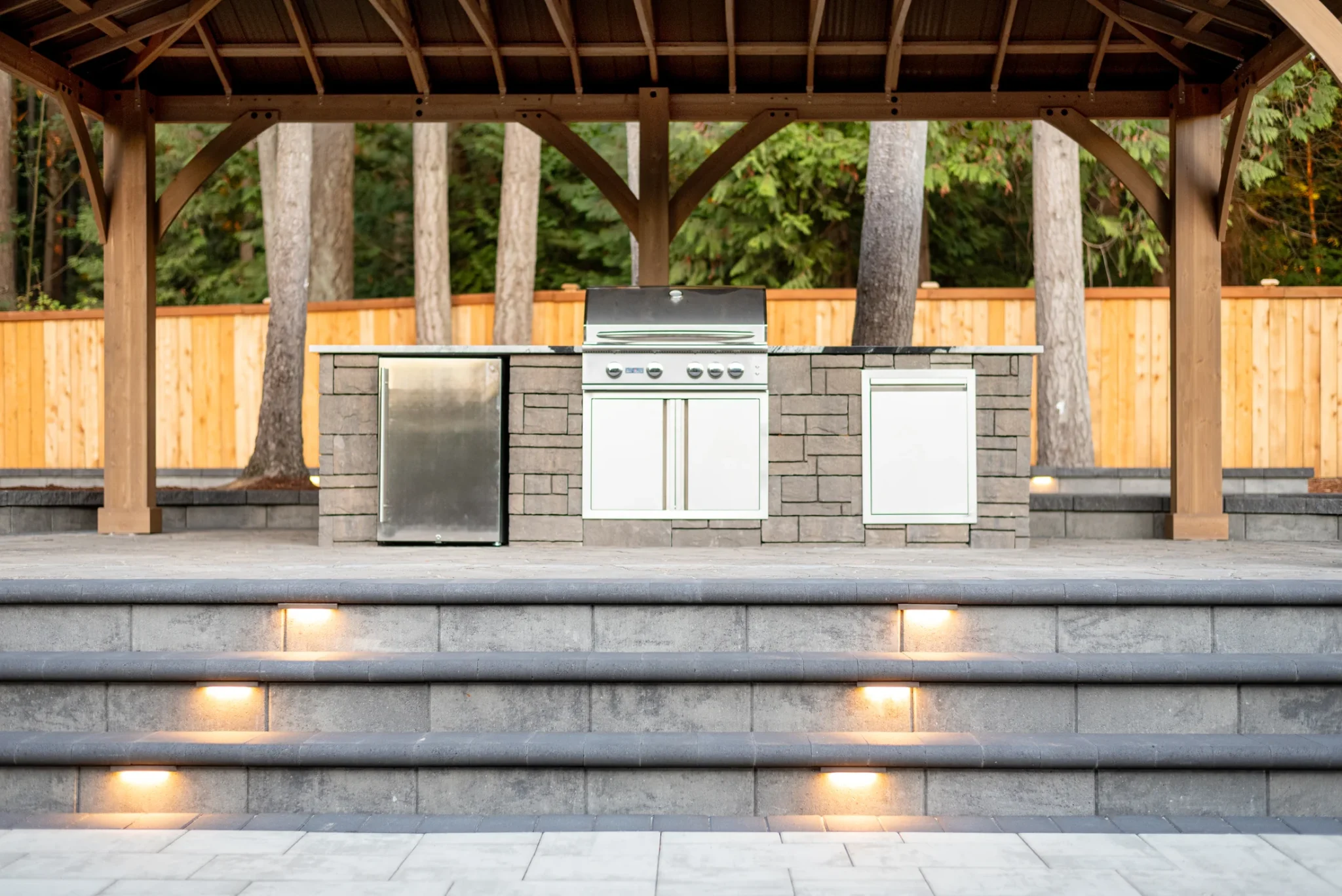 Illuminated paver steps connecting the outdoor living areas