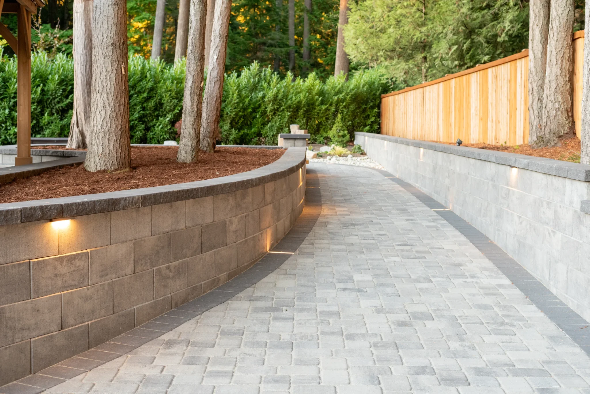 Paver walkway beside a curved retaining wall
