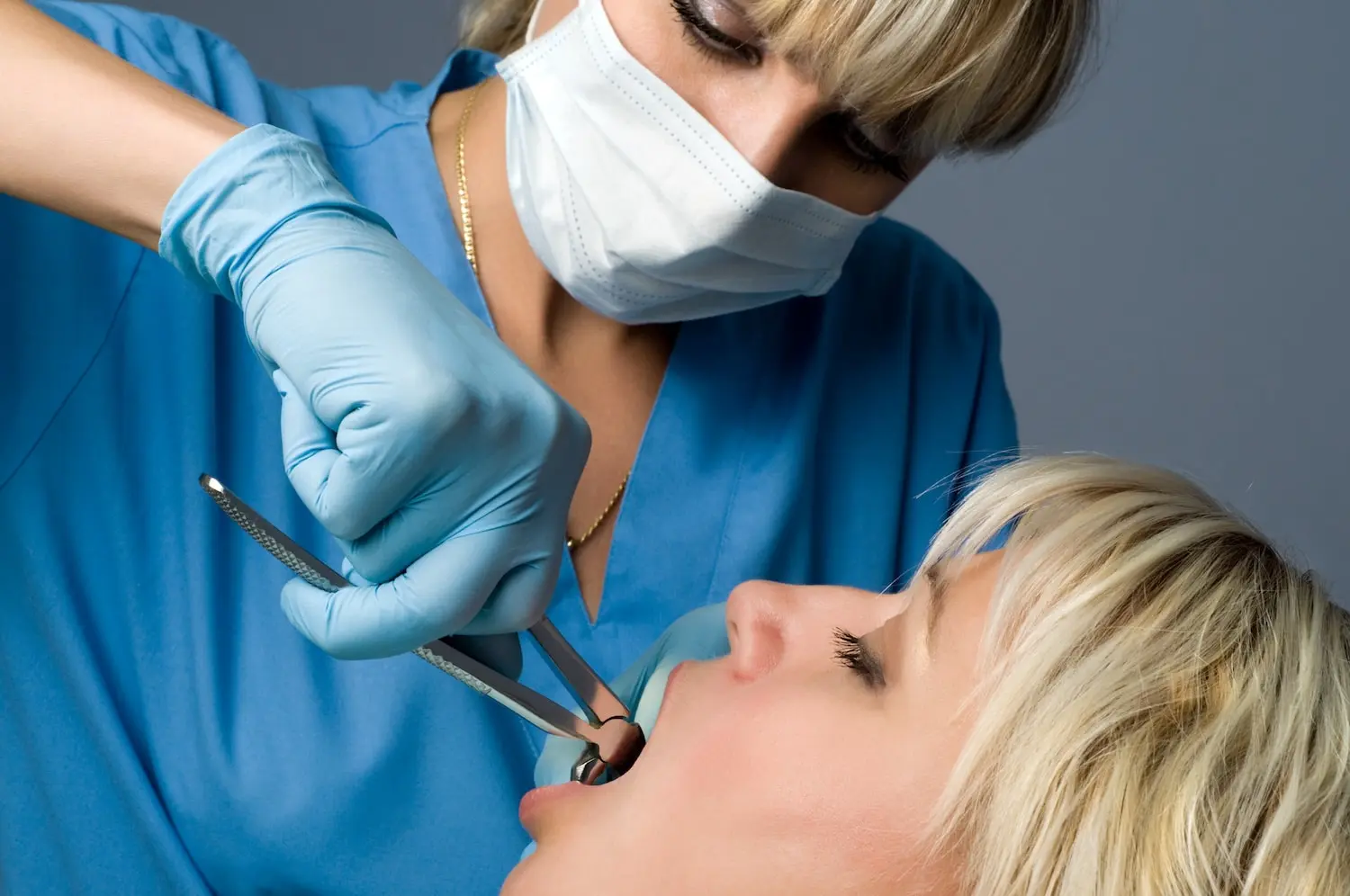 dry socket symptoms dentist performing tooth extraction on woman