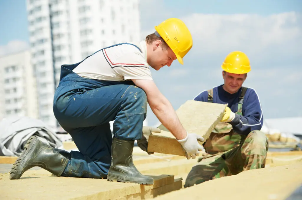 roof insulation-roofers installing flat roof insulation to commercial roof