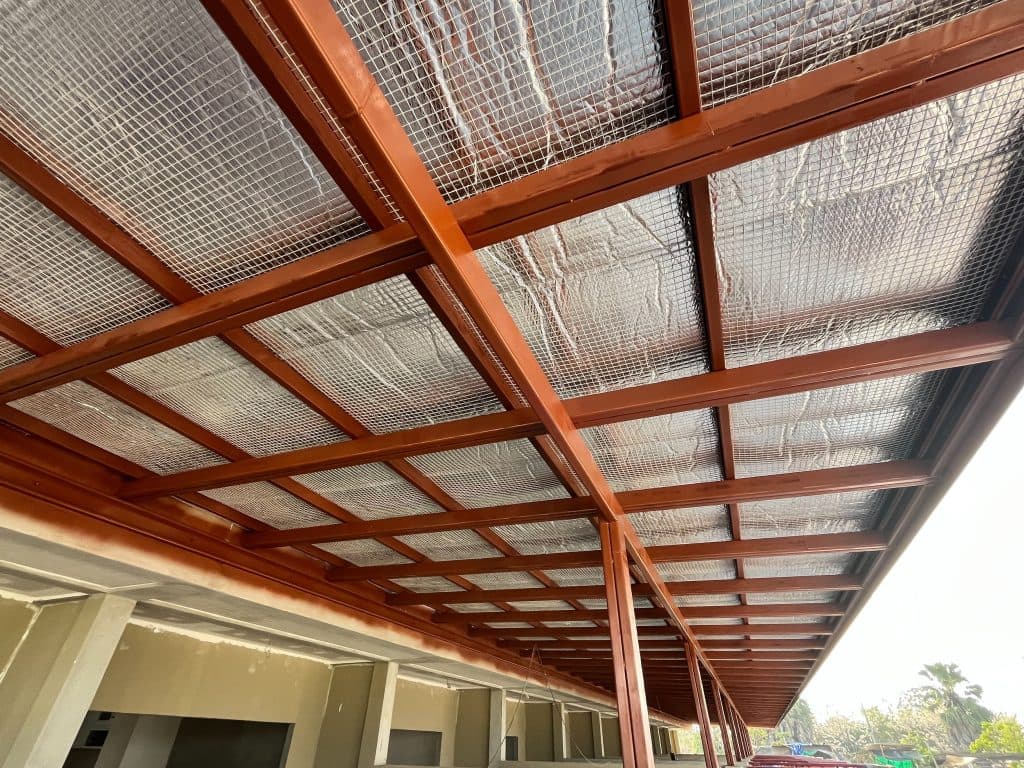 Steel roof structure with thermal insulation and metal mesh, perfect for industrial and commercial buildings.