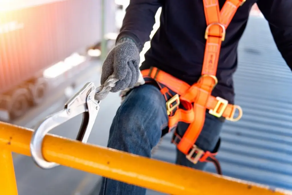 Construction worker use safety harness and safety line working on a new construction site project.Harness is a equipment for safety in construction site.
