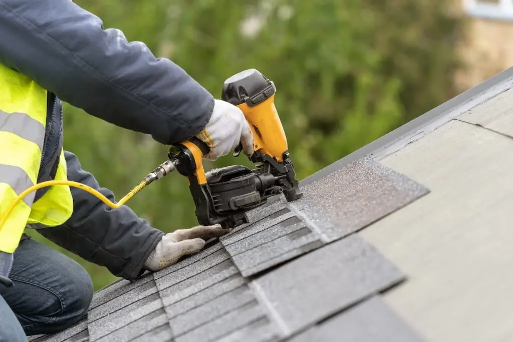 roofer installing shingles on new roof