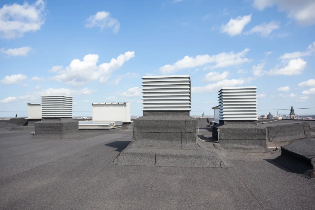 close up view of flat roofing system with vents and hvac