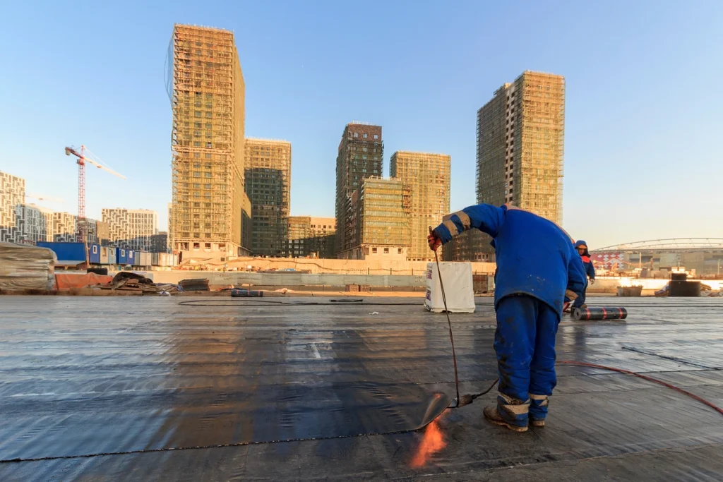 roof coatings-roof tech applying a waterproof coating to a commercial flat roof