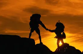 Two Hikers Holding Hands at Sunset