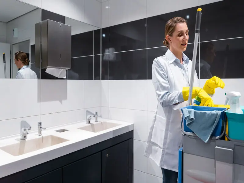 Janitor woman cleaning office restroom