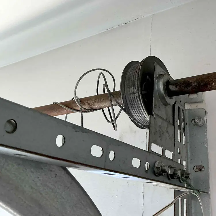 Alt Text: Snapped garage door cable wrapped around the torsion bar in Houston, TX