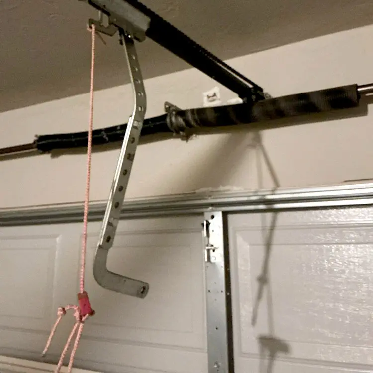 Broken garage door opener bracket with the opener arm disconnected before reinforcement repair in Oklahoma City, OK