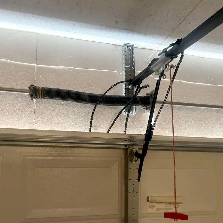 Broken garage door opener chain hanging from the rail after the gear-and-sprocket assembly failed in Oklahoma City, OK