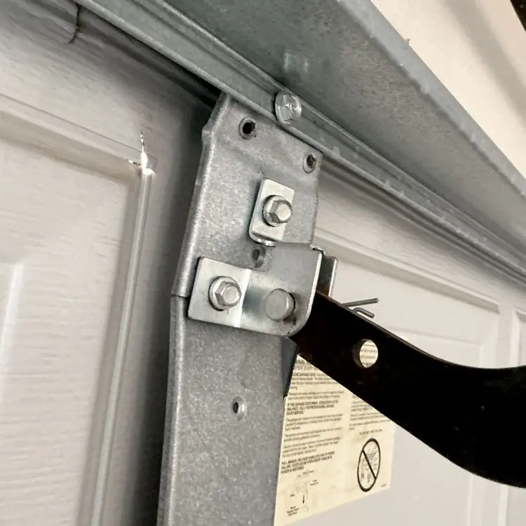 Garage door repair in Dallas, TX with an operator reinforcement bracket reinforcing a cracked garage door center stile.