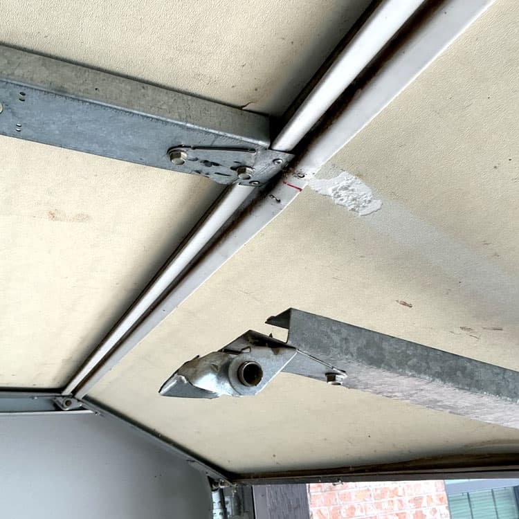 Snapped garage door hinge that pulled the center stile away before repair and hinge replacement in Oklahoma City, OK