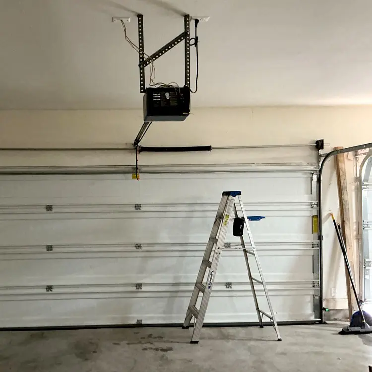 Residential garage door and opener receiving tune-up and maintenance service in Austin, TX
