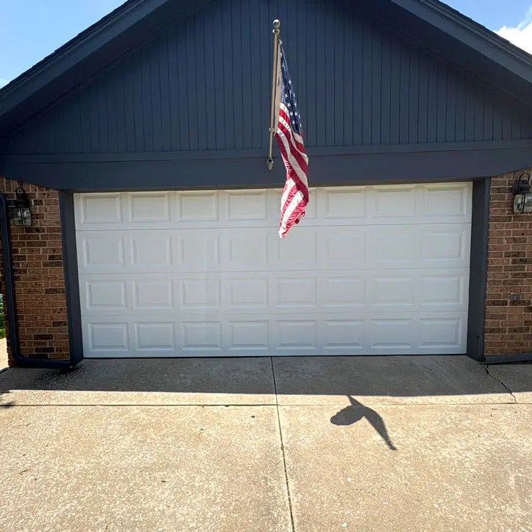 New white raised-panel garage door after replacing a door with a torn section in Oklahoma City, OK