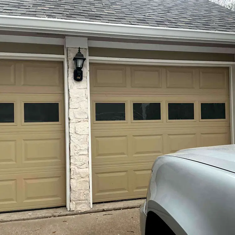 Traditional beige raised-panel garage doors before a modern upgrade in Allen, TX