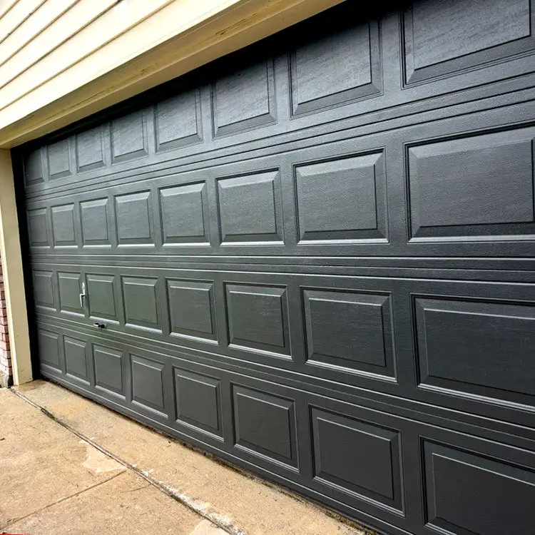 New black raised-panel garage door after replacing a white door with windows at a Tulsa, OK home