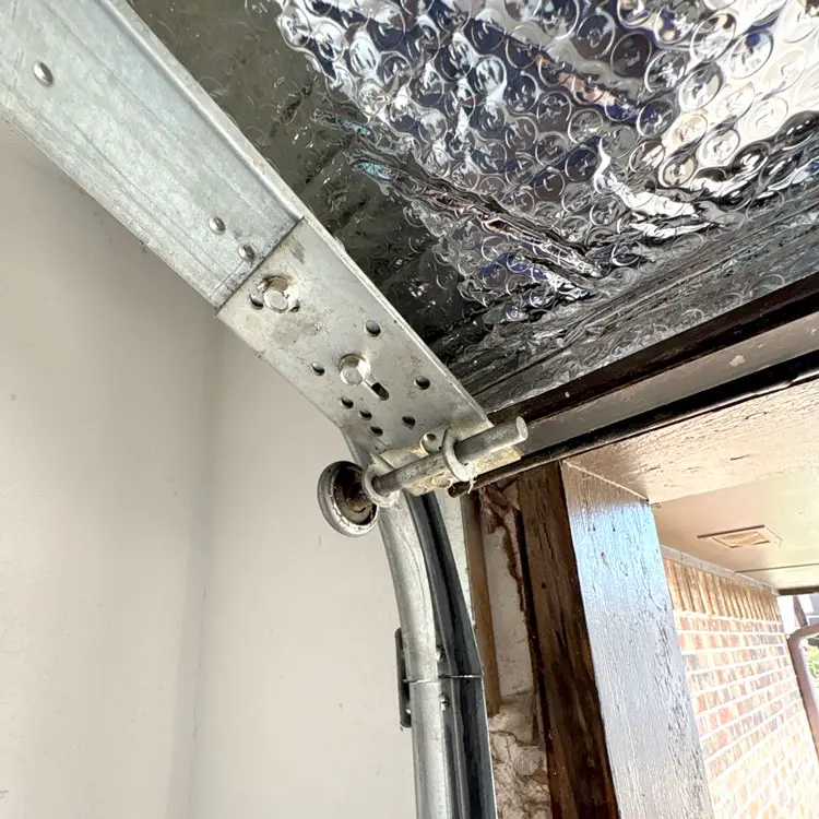 Garage door off track with a roller completely outside the vertical track in Oklahoma City, OK
